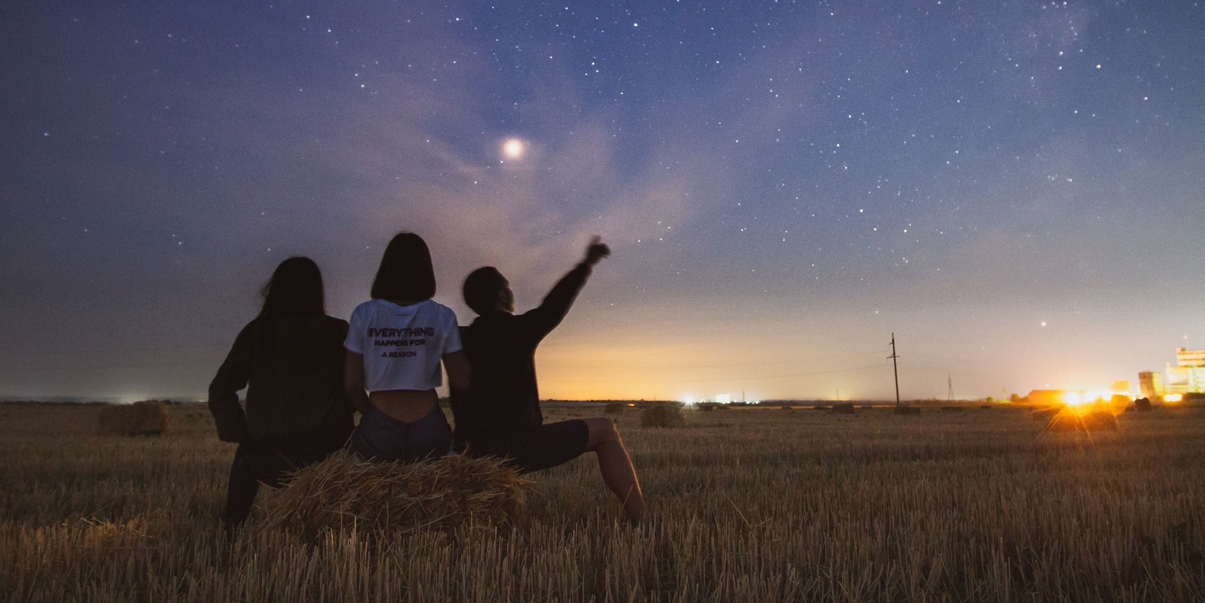 Image of people sitting under night sky