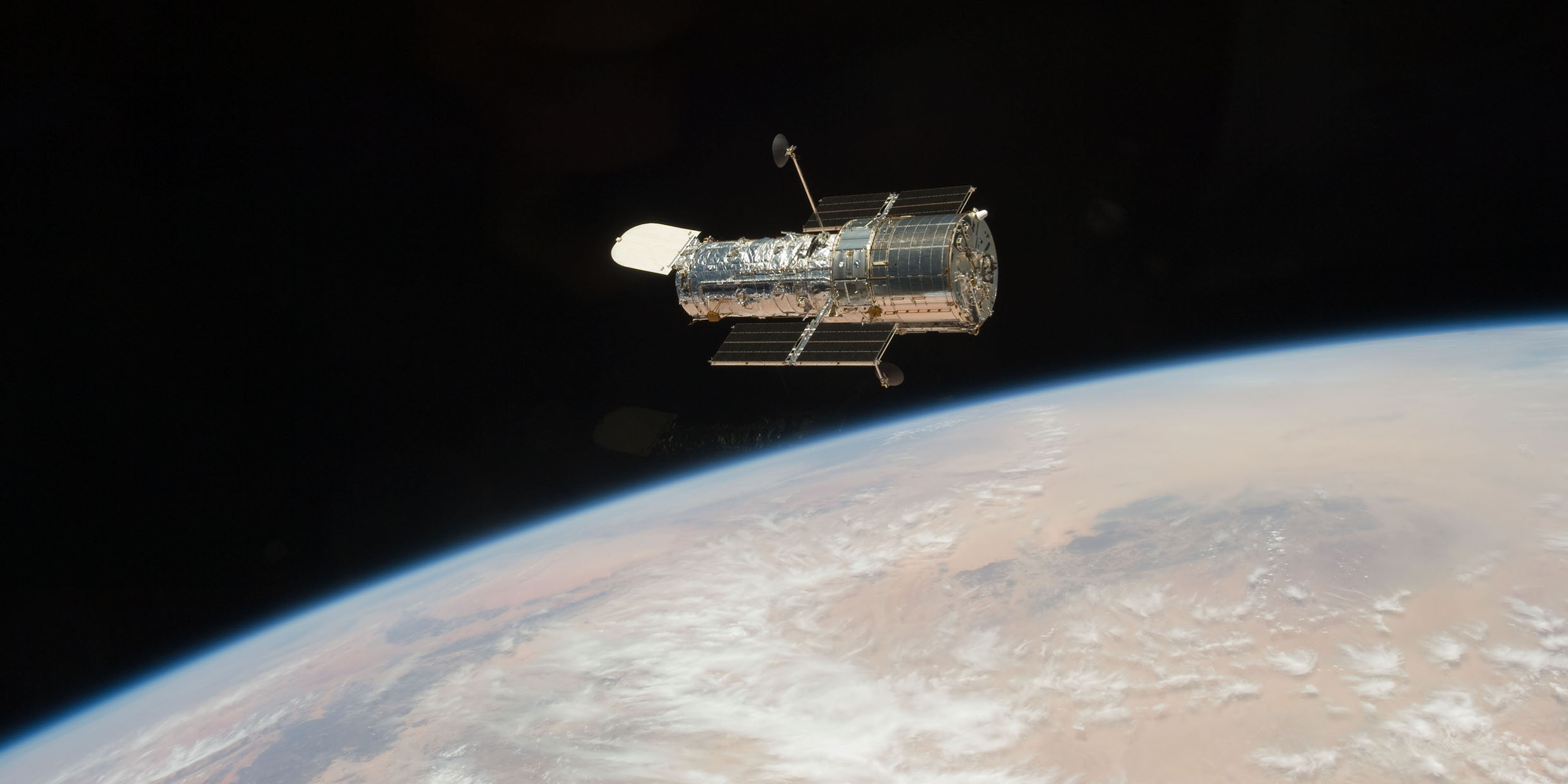 Image of the Hubble Space Telescope in orbit above Earth
