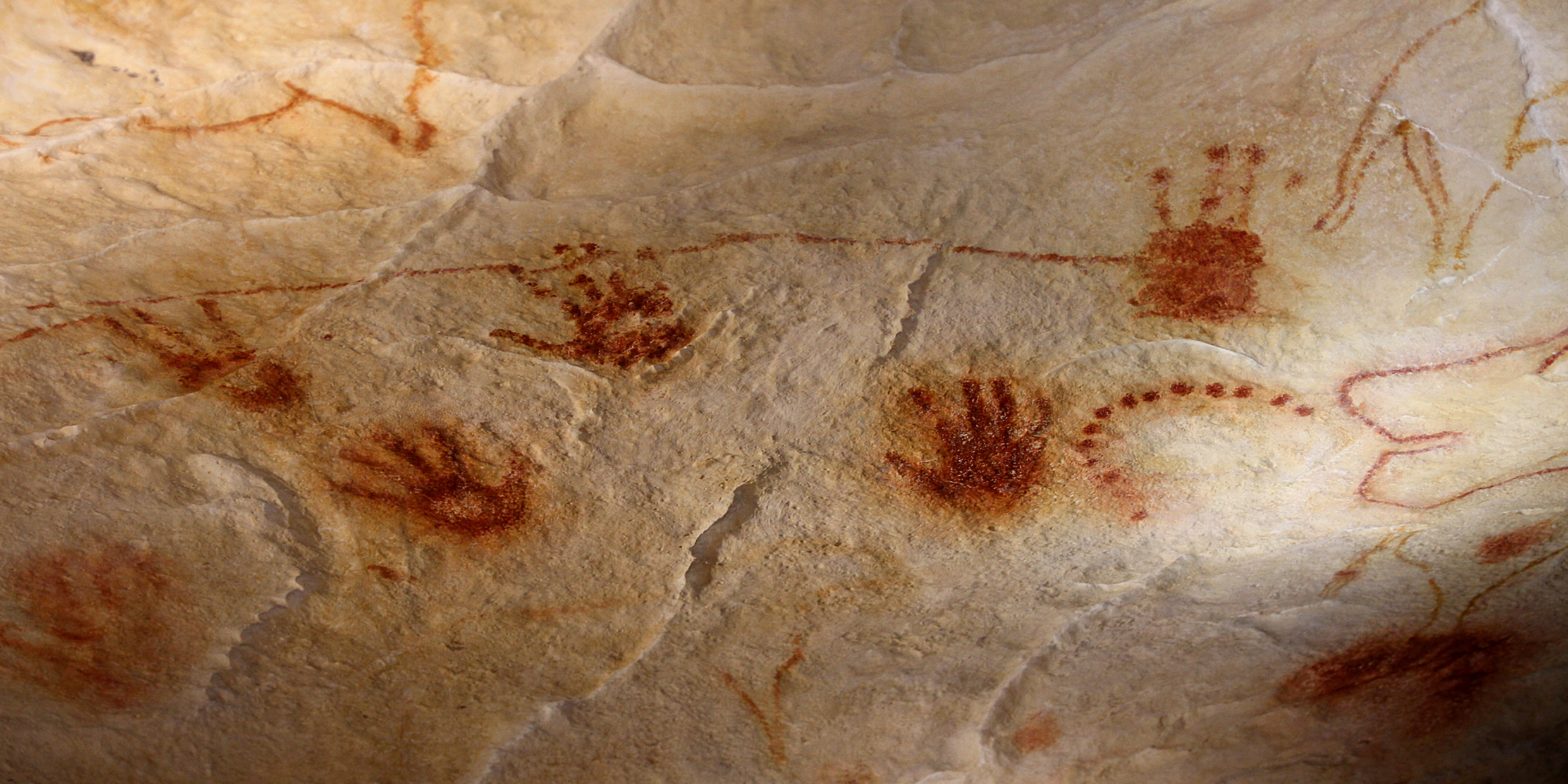 Image of human hand prints made on side of cave with red pigment