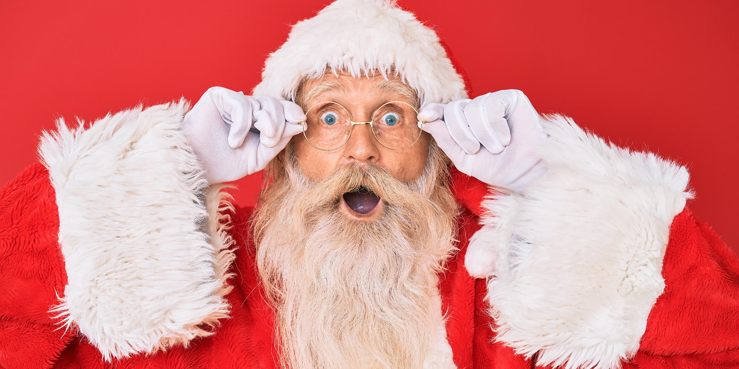 Image of a man with a surprised expression dressed as Santa Claus