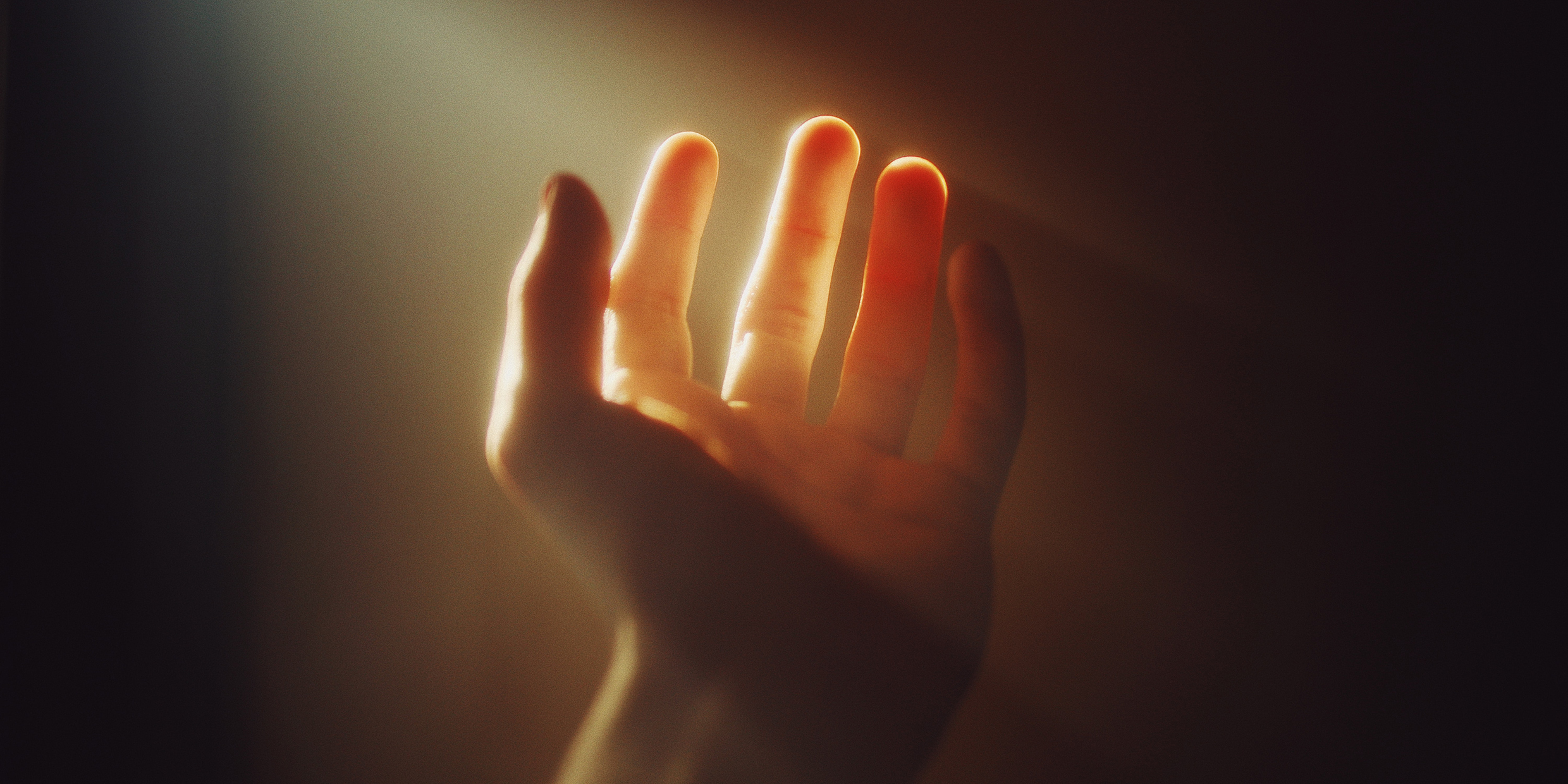 Image of a human hand bathed in a beam of light