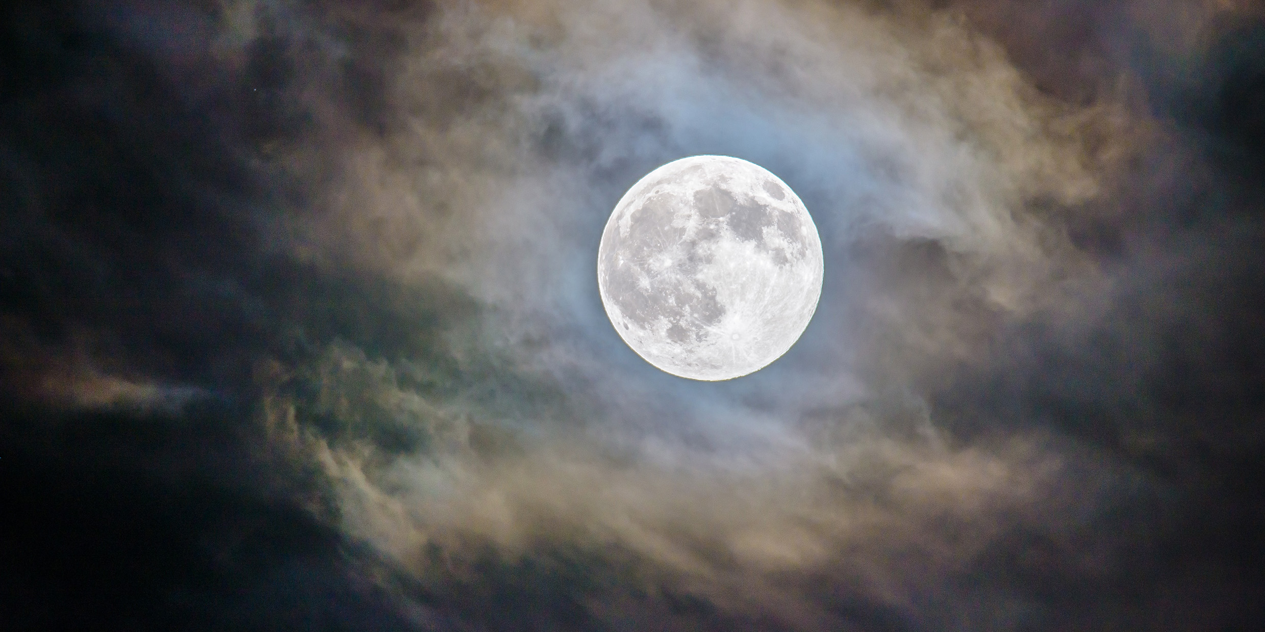 Image of a full moon in a cloudy sky