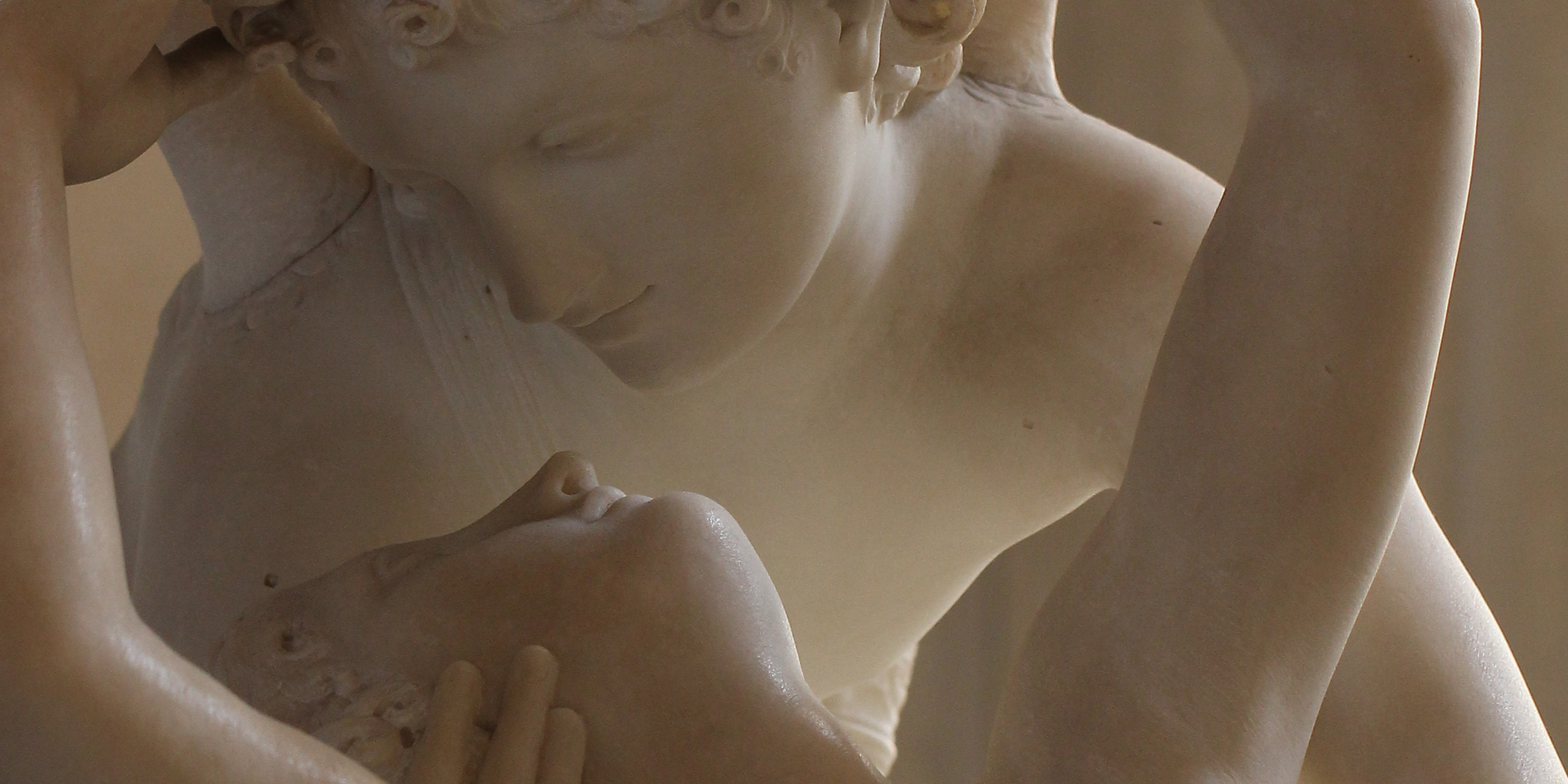 Image of a marble sculpture depicting a woman receiving a kiss from a winged man