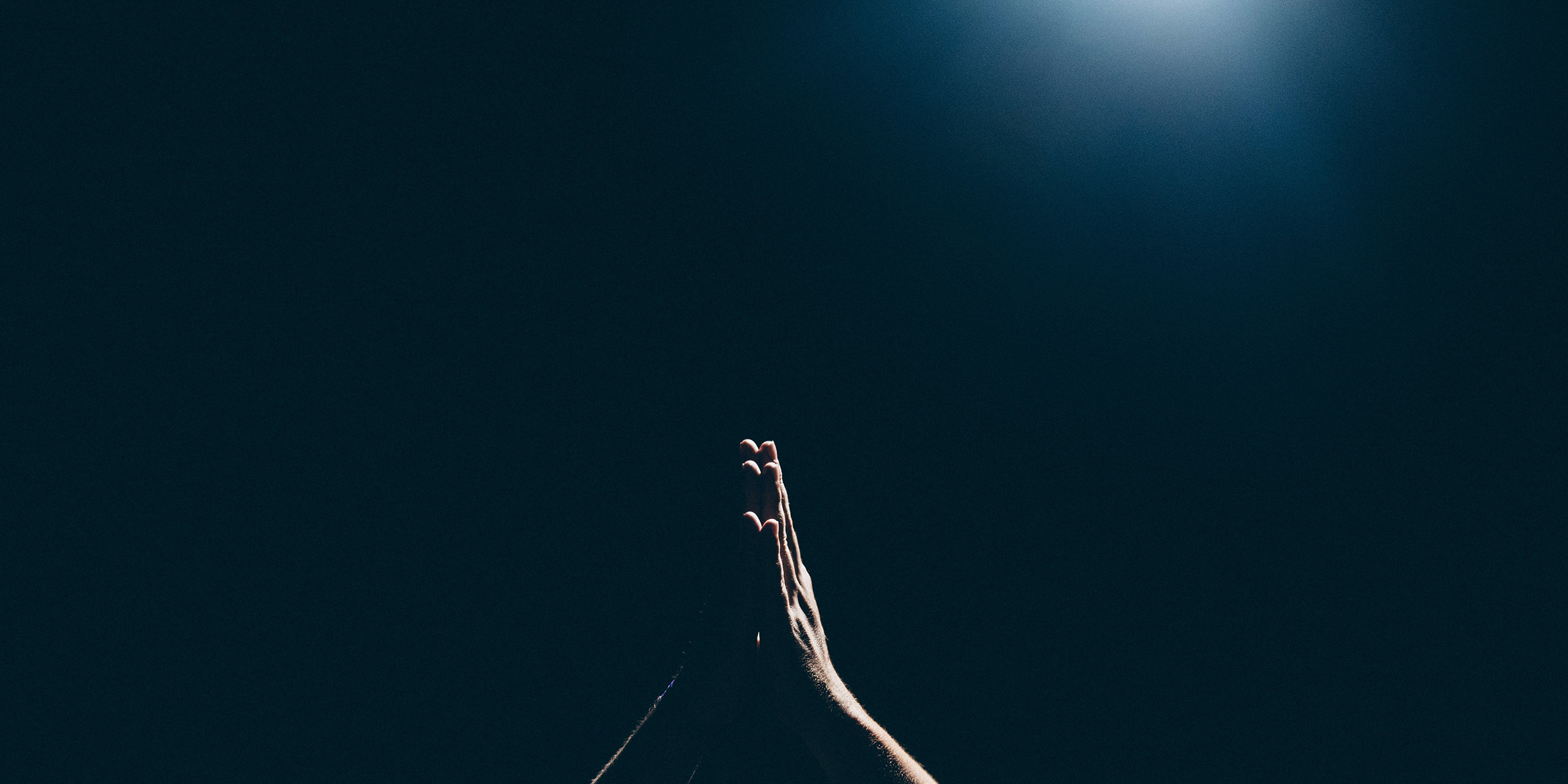 Image of praying hands with a dark background