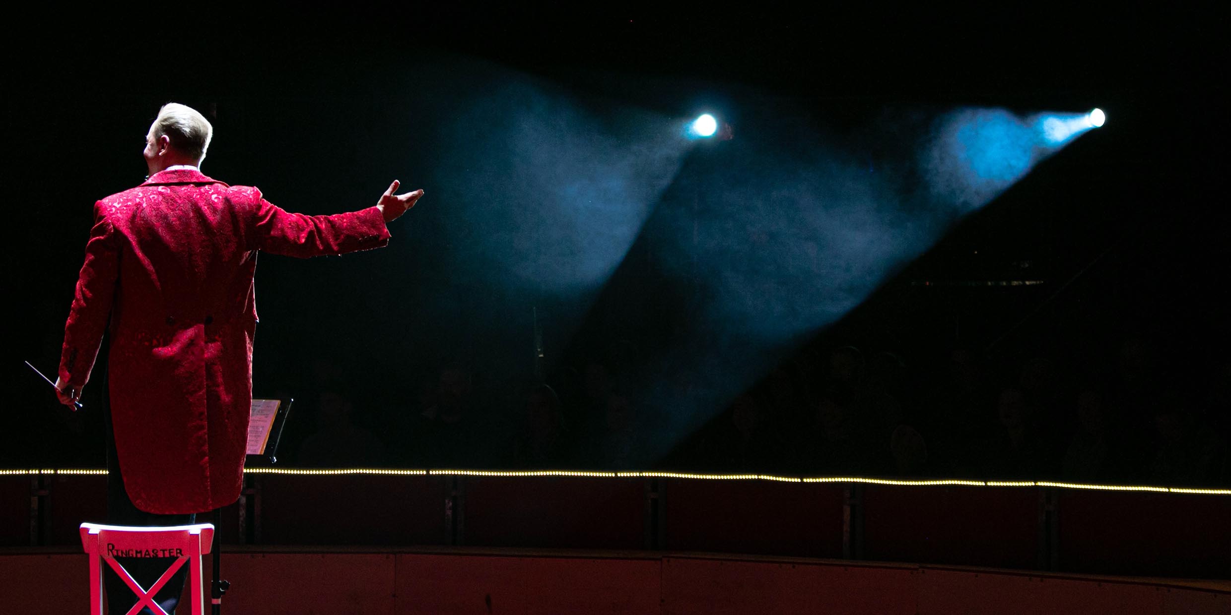 Image of a circus ringmaster gesturing to an unseen audience
